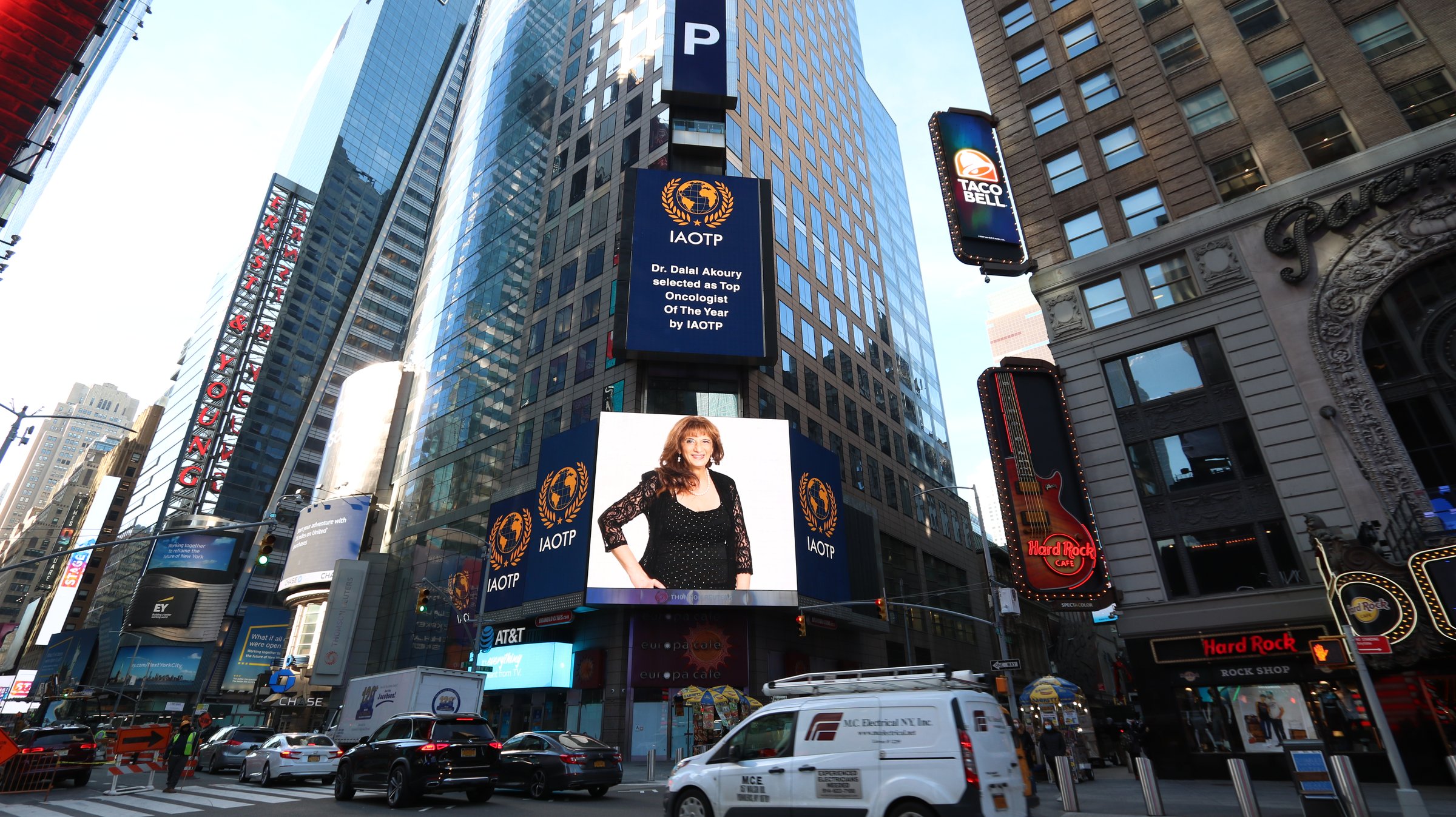A digital billboard above Times Square announcing Dr. Dalal Akoury as Top Oncologist of the Year