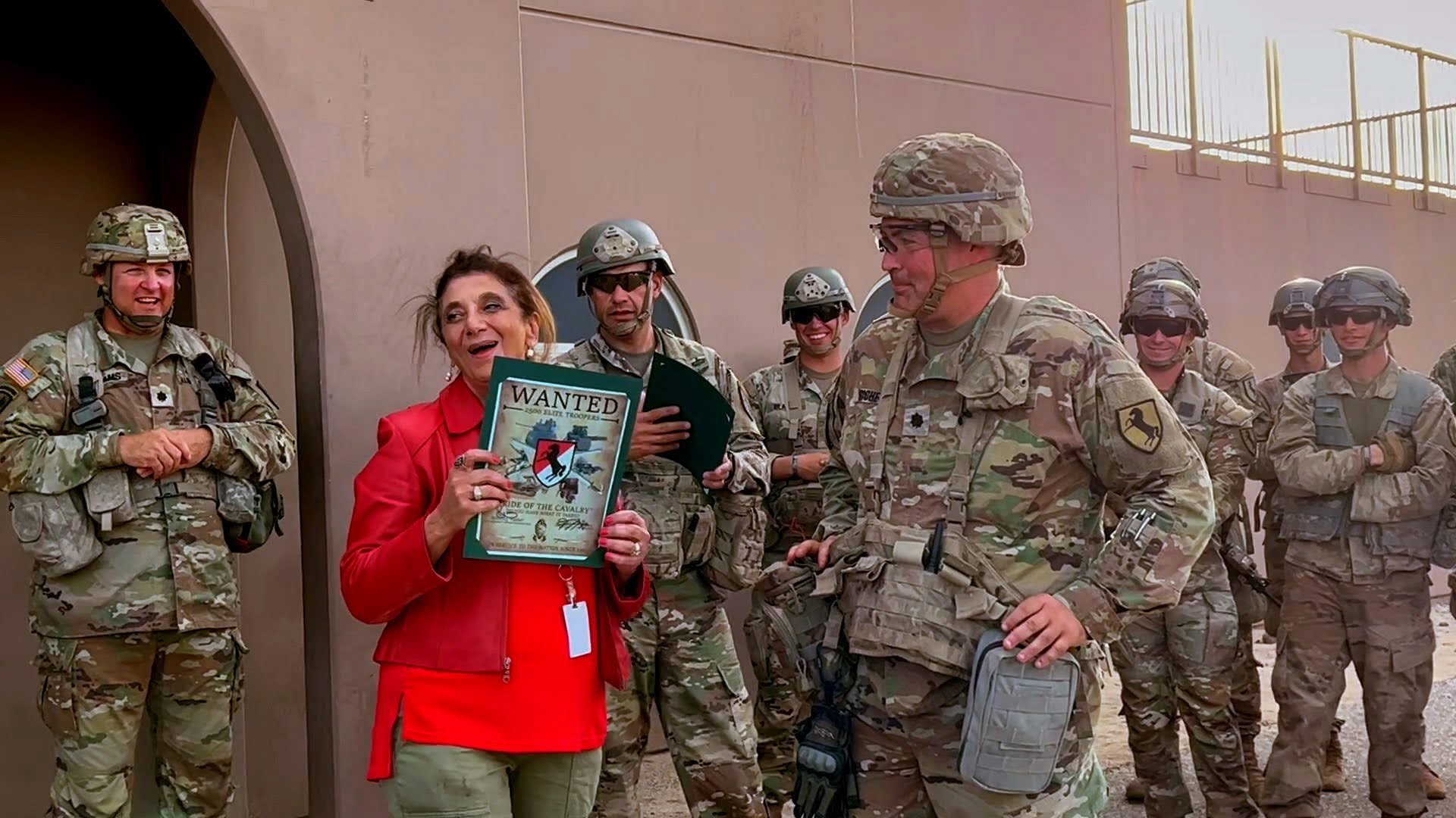 Dr. Dalal Akoury smiling alongside U.S. service members, reflecting her commitment to those who serve